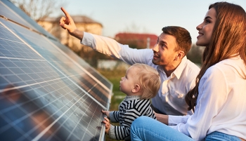 petite famille devant des panneaux solaires