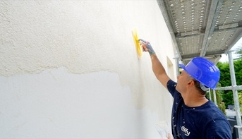 Artisan pose de l'enduit pour l'isolation des murs par l'extérieur