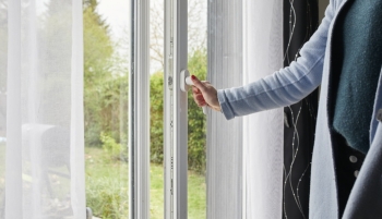 Femme ouvrant une porte fenêtre 